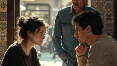 Photo of An Emotional Conversation Unfolds in a Quiet Café as an Unexpected Visitor Pauses to Listen at the Table